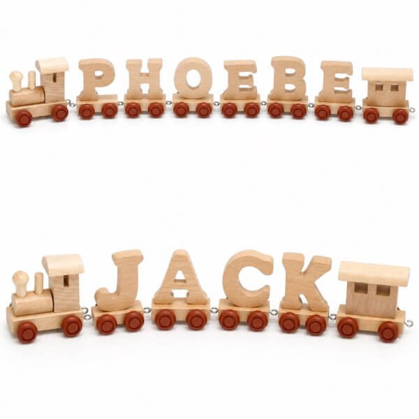 Wooden toy train carrying large letters spelling 'PHOEBE JACK' on red wheels.