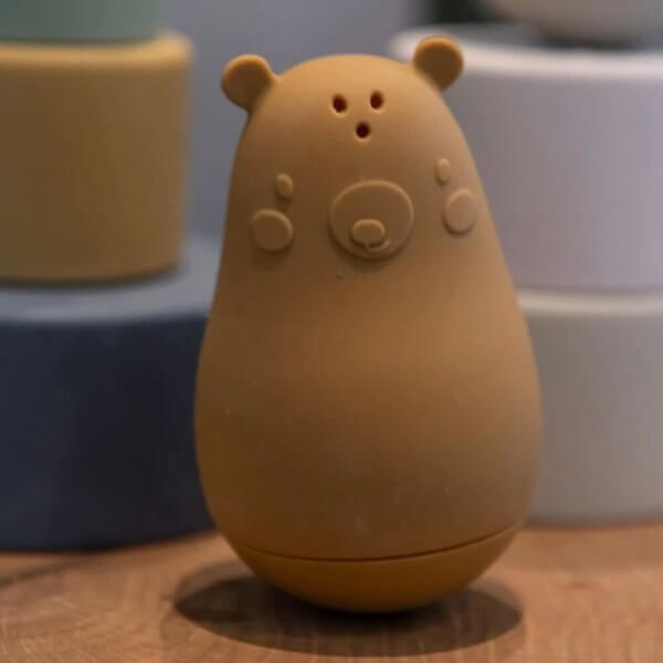 Nuuroo set of two bath toys | Bambino Eco Toys Brown bear-shaped silicone container or toy standing upright on a wooden surface, with small ears and button-like paws.