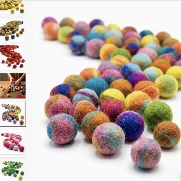 Namaste 100% wool felt balls range of colours | Bambino Eco Toys Colorful wool yarn balls arranged in a line on a white background.